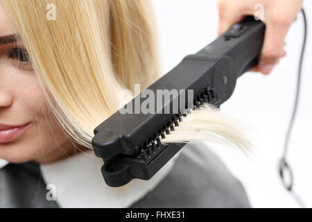 Ferro da stiro barbershops, capelli raddrizzatura.. Keratin Hair raddrizzatura.. Parrucchiere modelli di acconciature utilizzando la piastra per capelli . Foto Stock