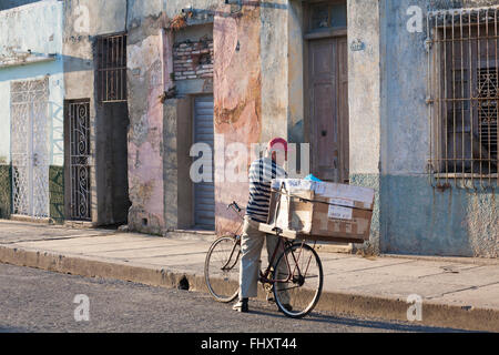 La vita quotidiana a Cuba - uomo offrendo il pane in strada dalla casella sulla bicicletta a Cienfuegos, Cuba Foto Stock
