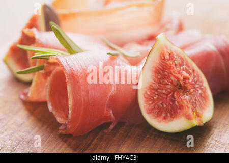 Secchi fette di prosciutto con fichi sul tavolo di legno Foto Stock