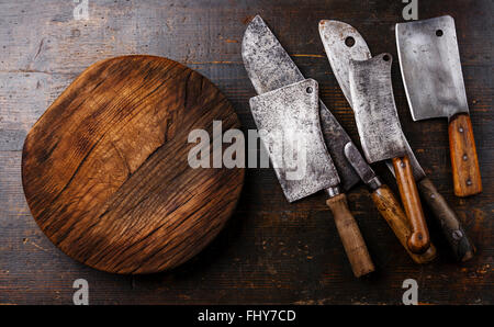 Butcher carne cleavers grandi coltelli chef e tagliere blocco su sfondo di legno Foto Stock