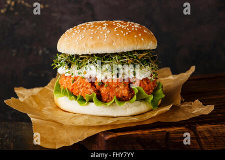 La carota burger con i germogli di trifoglio su sfondo scuro Foto Stock