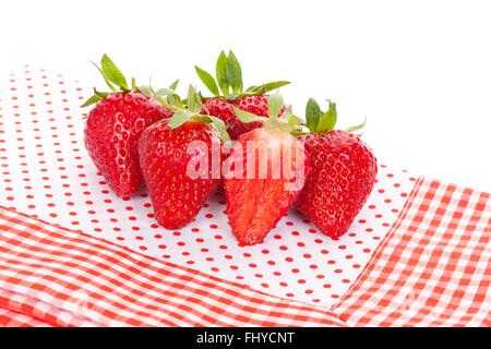 Deliziosa fragole mature su rosso e bianco sfondo tratteggiato. La frutta sana mangiare. Foto Stock