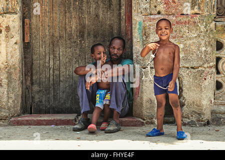 Stanco padre e due giovani figli, resto sulla strada della vecchia Havana, Cuba Foto Stock