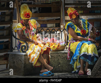 Le donne in colorate tradizionali abiti cubano in appoggio sulla strada a l'Avana, Cuba Foto Stock