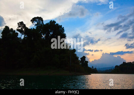 Tramonto e nuvole temporalesche su CHEOW EN lago in Khao Sok NATIONAL PARK - Tailandia Foto Stock