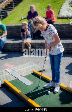 Modello rilasciato. Ragazza che gioca il mini golf. Foto Stock