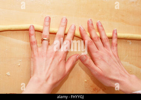 Impastare a casa sul tagliere di legno Foto Stock