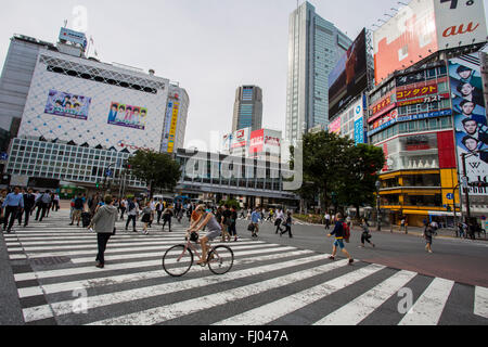 Un ciclista scorre attraverso la traversata di Shibuya di Tokyo, Giappone Foto Stock