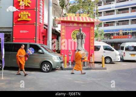 I monaci buddisti a piedi passato un santuario a Bangkok, in Thailandia Foto Stock