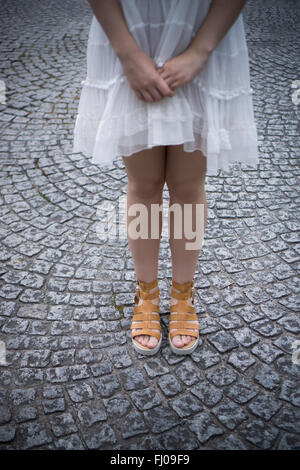 Donna in piedi sul lastricato della strada Foto Stock