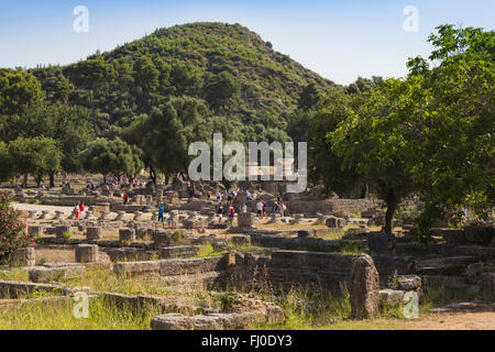 Olympia, Peloponneso e Grecia. Antica Olympia. Gruppi di visitatori di passeggiare attraverso le rovine. Foto Stock