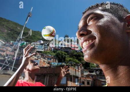 15-anni brasiliano di ragazzi che giocano a calcio in favela di Santa Marta, Rio de Janeiro, Brasile. Foto Stock