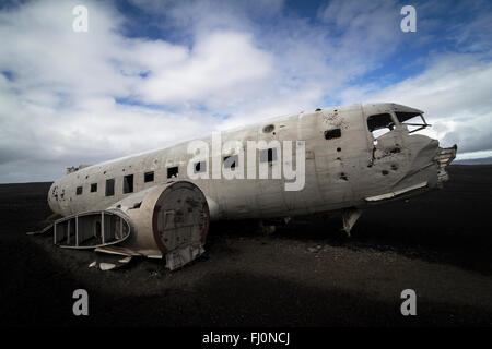 Il lato orizzontale vista di un relitto aereo sulle sabbie nere e sullo sfondo di un cielo blu nel sud dell'Islanda Foto Stock