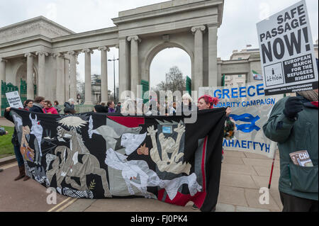 Londra, Regno Unito. Il 27 febbraio 2016. Persone a Hyde Park Corner tenere un banner realizzato da Brighton refugee support gruppi basati su Guernica di Picasso per il mese di marzo per un rally a Marble Arch lo stesso giorno di proteste in altre città in tutta Europa ad esigere che le autorità e i governi di agire ora per aprire un sicuro passaggio per tutti i rifugiati e i richiedenti asilo cercano protezione in Europa. Essi chiedono la fine di morti alle frontiere e per i profughi deve essere consentito di mantenere i loro possedimenti e ricongiungersi con le loro famiglie. Peter Marshall, Alamy Live News Foto Stock