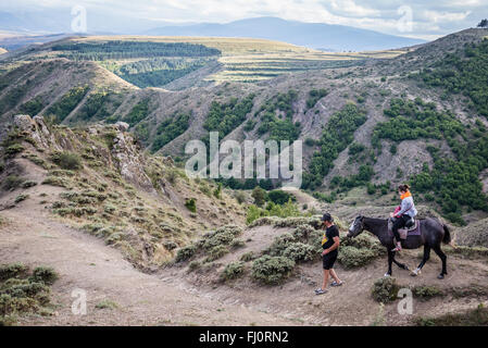 Equitazione per i turisti nei pressi di Atskuri città nella regione Samtskhe-Javakheti, Georgia Foto Stock