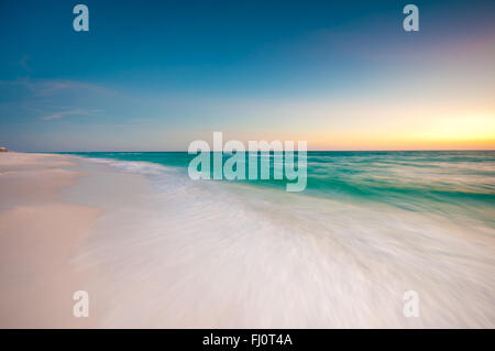 Una lunga esposizione di una forma d'onda durante un bellissimo tramonto sulla costa del Golfo della Florida Foto Stock