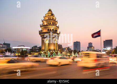 Rush traffico intorno al monumento di indipendenza, con la sua architettura Khmer stile, in Phnom Penh Cambogia città capitale. Sfocato Foto Stock