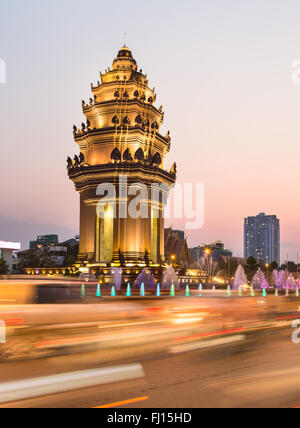 Rush traffico intorno al monumento di indipendenza, con la sua architettura Khmer stile, in Phnom Penh Cambogia città capitale. Sfocato Foto Stock