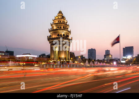 Rush traffico intorno al monumento di indipendenza, con la sua architettura Khmer stile, in Phnom Penh Cambogia città capitale. Sfocato Foto Stock