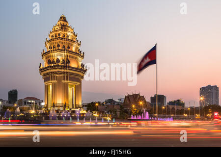 Rush traffico intorno al monumento di indipendenza, con la sua architettura Khmer stile, in Phnom Penh Cambogia città capitale. Sfocato Foto Stock