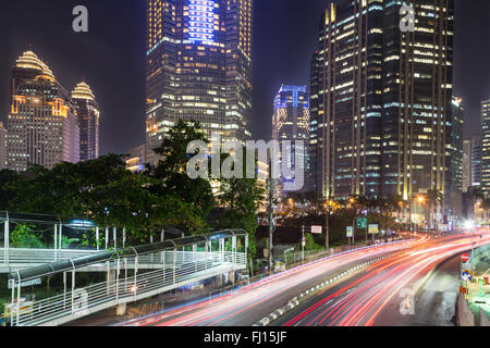 Il traffico di notte a Giacarta, lungo Indonesia città capitale viale principale rivestita con banche , hotel di lusso e centri commerciali (Jalan Foto Stock