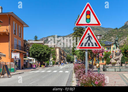 Segni di traffico sulla strada tra le piccole case colorate in tenda - piccola cittadina francese. Foto Stock