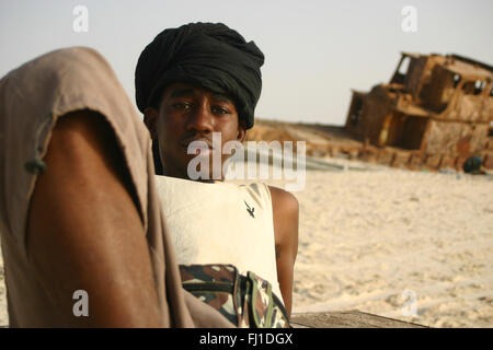 Uomo nero sulla spiaggia e porto tradizionale di Nouakchott , Mauritania Foto Stock