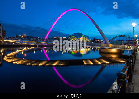 Una vista notturna di Gateshead Millennium Bridge si riflette nel fiume Tyne con il Sage Gateshead & sul Tyne Bridge in background Foto Stock
