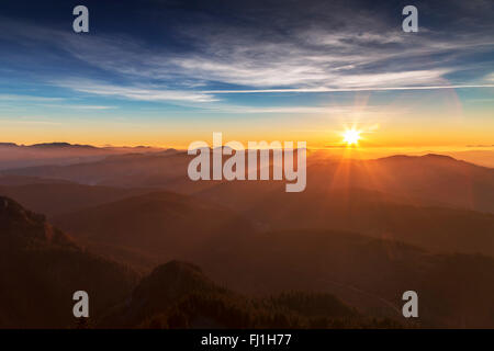 Sunrise oltre le creste di montagna Foto Stock