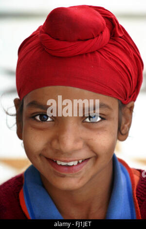 Punjabi Sikh kid bambino ragazzo indossa turbante rosso di Amritsar , India Foto Stock