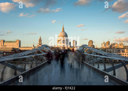 La sfocatura in movimento di persone che attraversano il Millennium Bridge, Londra Foto Stock
