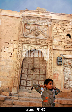 Il ragazzo si trova all'ingresso di un haveli in Jaisalmer , India Foto Stock