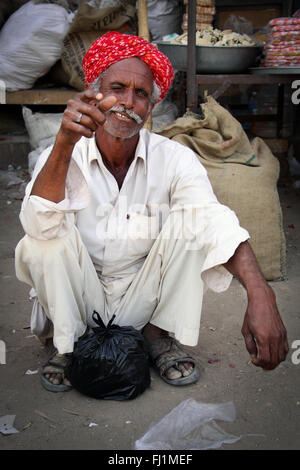 Nizza uomo di Rajasthani giging un occhiolino con turbante rosso e i baffi in Jaisalmer , India Foto Stock