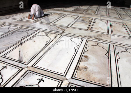 Uomo musulmano di pregare sul pavimento in Jama Masjid / grande moschea di Delhi, India Foto Stock