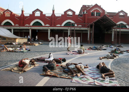 Dormire la gente ruvida in strada la mattina presto di fronte al nuovo mercato , Kolkata , India Foto Stock