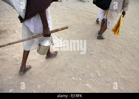 Pellegrini in cammino con la brocca e a piedi nudi durante il Kumbh Mela 2010 a Haridwar, India Foto Stock