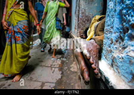 Piedi di uomo dorme in una strada stretta di Varanasi , India Foto Stock