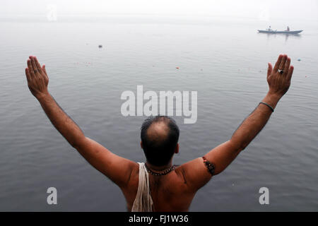 Persone in preghiera sulle rive del Gange a Varanasi , India Foto Stock