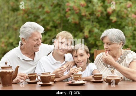 Famiglia bere il tè in giardino Foto Stock