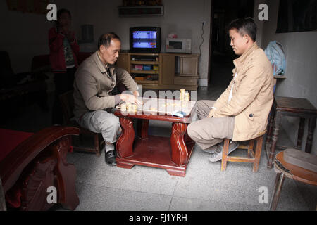 Due uomini giocare a scacchi a casa in Zhenyuan, Guizhou, Cina Foto Stock