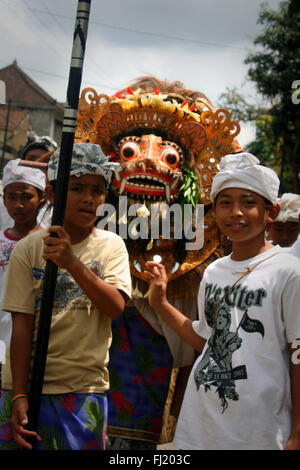 I bambini a camminare in una strada di Ubud con Barong figura, Bali , Indonesia Foto Stock