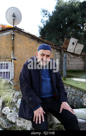 Un uomo si siede di fronte a una casa in zona Fatih , Istanbul Foto Stock