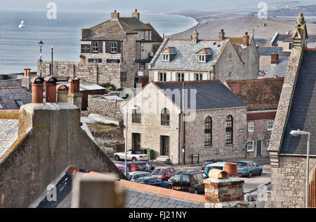 Vista guardando attraverso tetti al cove house inn e dietro che chesil beach Foto Stock