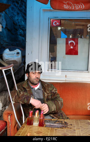 Uomo seduto con bagno turco bandiera nazionale in Istanbul , Turchia Foto Stock