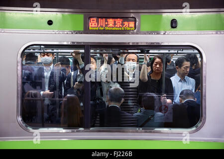 La folla e il traffico delle ore di punta al mattino presto per i dipendenti nella metropolitana di Tokyo , Giappone Foto Stock