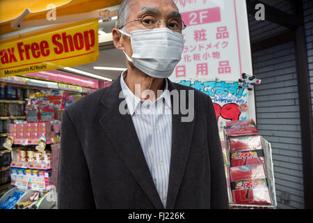 Uomo giapponese indossa maschera chirurgica a Tokyo Foto Stock
