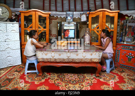 Due ragazze sono a guardare la TV in una casa tradizionale chiamato ger o yurt in Mongolia Foto Stock