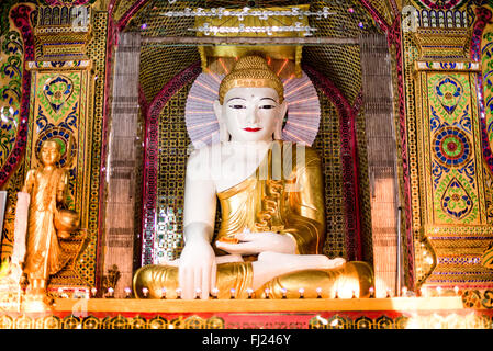 MANDALAY, Myanmar - la Pagoda Sutaungpyei si trova in cima alla collina Mandalay, offrendo vedute panoramiche della città sottostante. Lo stupa dorato della pagoda brilla alla luce del sole, circondato da padiglioni e santuari ornati. Visitatori e pellegrini esplorano il complesso del tempio, alcuni si fermano per pregare o fare offerte presso le varie statue di Buddha. Foto Stock