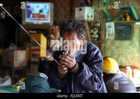 Uomo di fumare in Nyaung Shwe, Myanmar (Birmania) Foto Stock