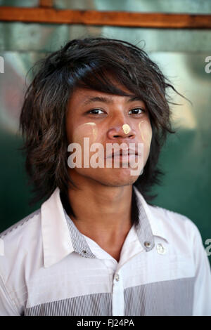 Ritratto di guy birmano con polvere di thanaka sul suo volto, Rangoon, Myanmar Foto Stock